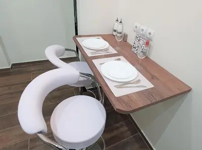 a wooden table with two white plates and chairs at WHITE HOUSE 30 steps from the Metro station in Athens