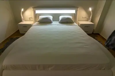 a large white bed with two nightstands in a bedroom at WHITE HOUSE 30 steps from the Metro station in Athens
