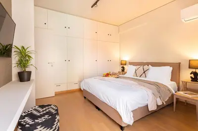 a bedroom with a large bed and white cabinets at Acropolis View 2-Bedroom Apt, Minimal-Safari Vibe, Big Balcony! in Athens