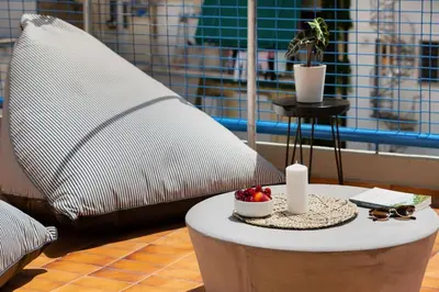 a table with a pillow and a table with fruit on it at Acropolis View 2-Bedroom Apt, Minimal-Safari Vibe, Big Balcony! in Athens