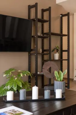 a living room with a tv and a table with plants at Acropolis View 2-Bedroom Apt, Minimal-Safari Vibe, Big Balcony! in Athens