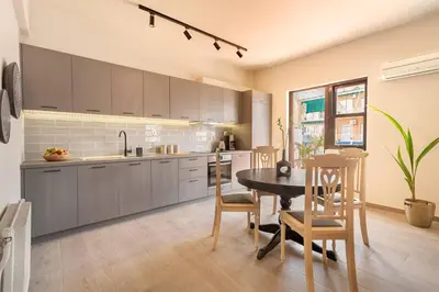 a kitchen with a table and some chairs and a table and a kitchen at Acropolis View 2-Bedroom Apt, Minimal-Safari Vibe, Big Balcony! in Athens