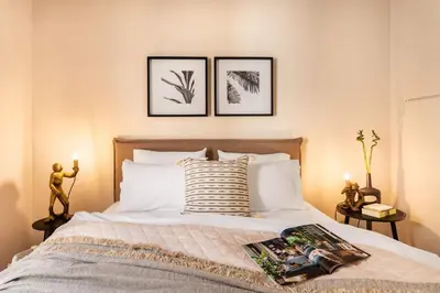 a bedroom with a bed with two pictures on the wall at Acropolis View 2-Bedroom Apt, Minimal-Safari Vibe, Big Balcony! in Athens