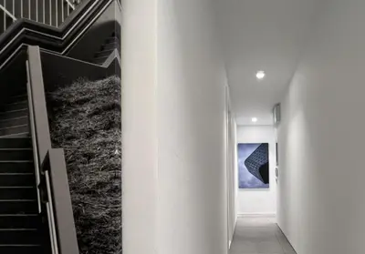 a hallway with white walls and stairs in a house at The Dazzling Glimpse Acropolis Suites in Athens