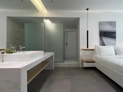 a bathroom with a large sink and a bed at The Dazzling Glimpse Acropolis Suites in Athens