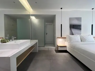 a bedroom with a bed and a tub and a sink at The Dazzling Glimpse Acropolis Suites in Athens
