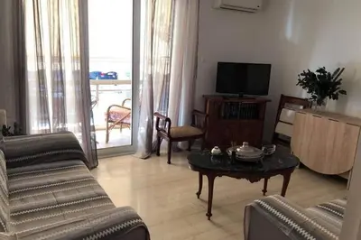 a living room with a couch and a table and a television at Cosy & Functional pied-à-terre in Athens