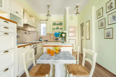 a kitchen with a table with chairs and orange juice at Bright, Calming Retreat With a Balcony Near Metro! in Athens