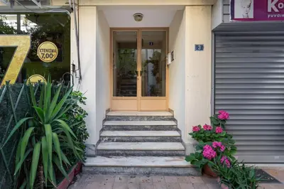 a front door of a house with stairs and flowers at Bright, Calming Retreat With a Balcony Near Metro! in Athens