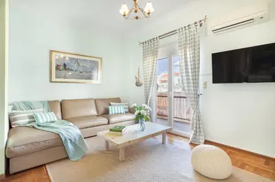 a living room with a couch and a table at Bright, Calming Retreat With a Balcony Near Metro! in Athens