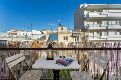 a table and chairs on a balcony with a building at Bright, Calming Retreat With a Balcony Near Metro! in Athens