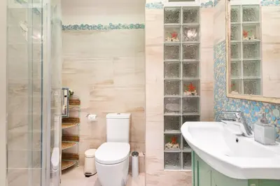 a bathroom with a toilet and a sink and a shower at Bright, Calming Retreat With a Balcony Near Metro! in Athens