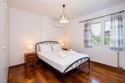 a white bedroom with a bed and a window at Beautifully renovated flat in superb location in Athens