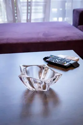 a glass bowl on a table next to a remote control at Beautifully renovated flat in superb location in Athens