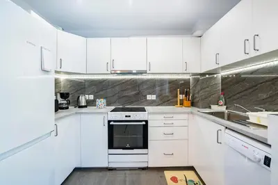 a white kitchen with a stove and a sink at Beautifully renovated flat in superb location in Athens