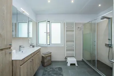 a bathroom with a sink and a glass shower at Beautifully renovated flat in superb location in Athens