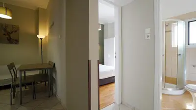 a room with a table and a bathroom with a bed at athens city themis 11 in Athens