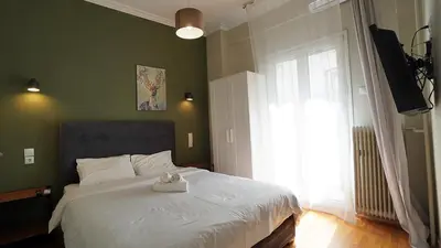 a bedroom with a large white bed with a window at athens city themis 11 in Athens