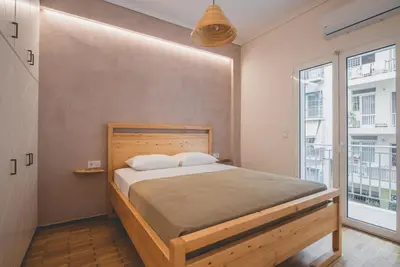 a bedroom with a bed and a large window at 90m2 Luxury Apartment in the Heart of Athens - Living Stone Sunstone in Athens