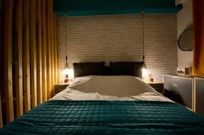 a bedroom with a green and white bed with a brick wall at Thissio, Downtown Athens by 'Philoxenia In Athens' in Athens