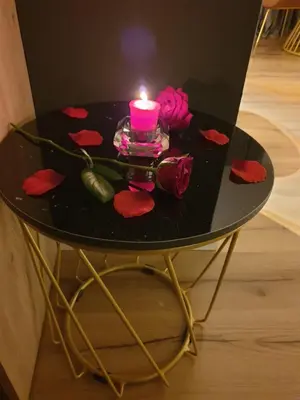 a candle on a black table with roses on it at EcoStay-Serenity,business class apartment by the sea in Alimos Kalamaki in Athens