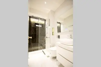 a white bathroom with a shower and a toilet at EcoStay-Serenity,business class apartment by the sea in Alimos Kalamaki in Athens