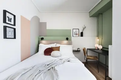 a bedroom with a large white bed with a desk at Iconic 1BR Apartment in Koukaki by UPSTREET in Athens
