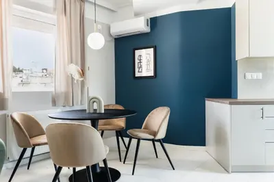 a dining room with a blue wall and a table and chairs at Iconic 1BR Apartment in Koukaki by UPSTREET in Athens