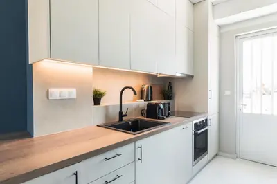 a kitchen with white cabinets and a sink at Iconic 1BR Apartment in Koukaki by UPSTREET in Athens