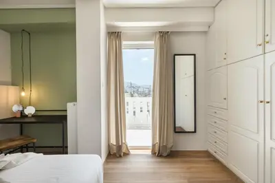 a bedroom with a bed and a large window at Iconic 1BR Apartment in Koukaki by UPSTREET in Athens