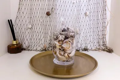 a glass vase filled with shells on a table at Blue And White Apartment VIPGreece in Athens