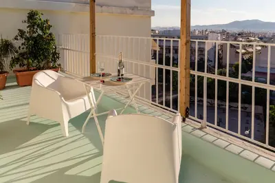 a balcony with a table and chairs and a view at Blue And White Apartment VIPGreece in Athens