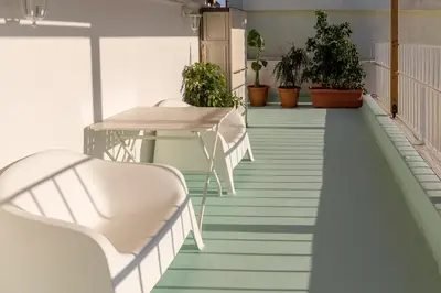 a table and chairs on a balcony with plants at Blue And White Apartment VIPGreece in Athens