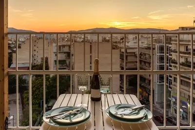 a bottle of wine sitting on a table on a balcony at Blue And White Apartment VIPGreece in Athens