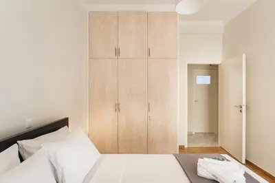 a bedroom with a bed and a wooden cabinet at La maison de Philopappou in Athens