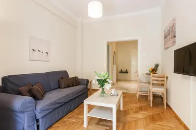 a living room with a blue couch and a table at La maison de Philopappou in Athens
