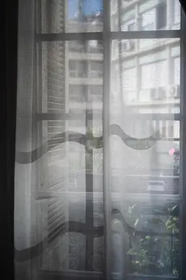 a view of a window with a curtain at Polytimon, an Athenian neoclassical apartment in Athens