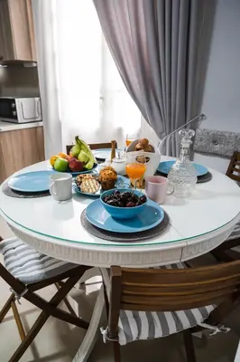 a table with plates of food and fruit on it at Polytimon, an Athenian neoclassical apartment in Athens