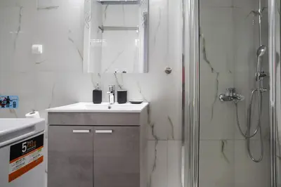 a bathroom with a shower and a sink and a mirror at Polytimon, an Athenian neoclassical apartment in Athens