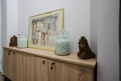two glass vases on a wooden shelf with a painting at Polytimon, an Athenian neoclassical apartment in Athens