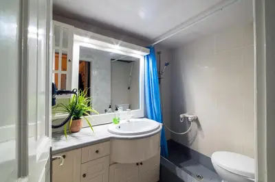 a bathroom with a sink and a toilet and a mirror at Acropolis Crib Spot in Athens