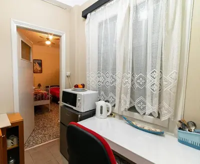 a kitchen with a counter with a microwave and a window at Acropolis Crib Spot in Athens