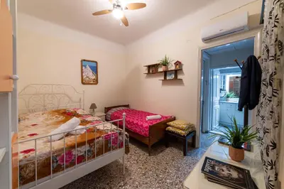 a bedroom with a bed and a chair and a window at Acropolis Crib Spot in Athens