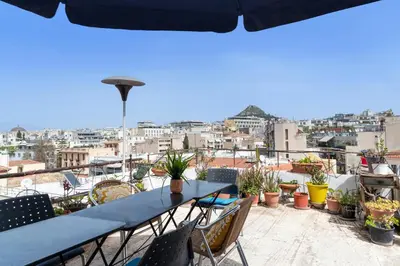 a table and chairs on a balcony with a view at Acropolis Crib Spot in Athens