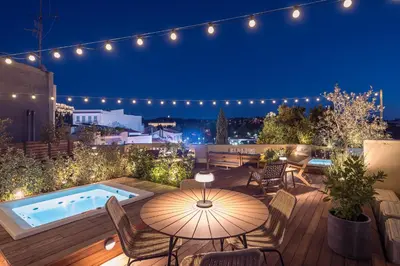 a patio with a table and chairs and a swimming pool at Moon And Stars Athens in Athens
