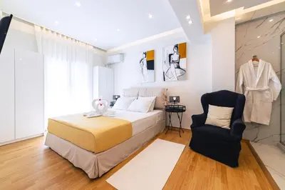 a bedroom with a bed and a chair at D9 center of Glyfada in Athens