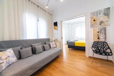 a living room with a couch and a bedroom at D9 center of Glyfada in Athens