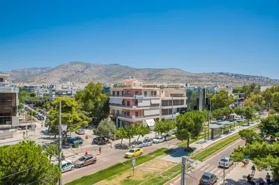 a city with buildings and a street with cars at D9 center of Glyfada in Athens