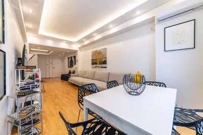 a living room with a couch and a table and chairs at D9 center of Glyfada in Athens