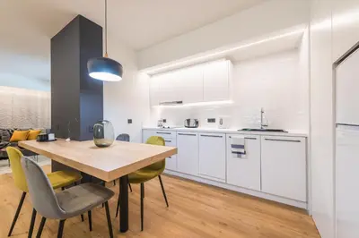 a kitchen and dining room with a wooden table and chairs at Brand New Ermou Veni Apartment in Athens